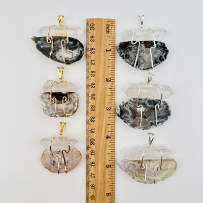 pendants next to a ruler for size reference 