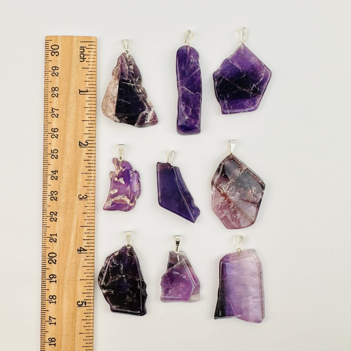 amethyst pendants next to a ruler for size reference 