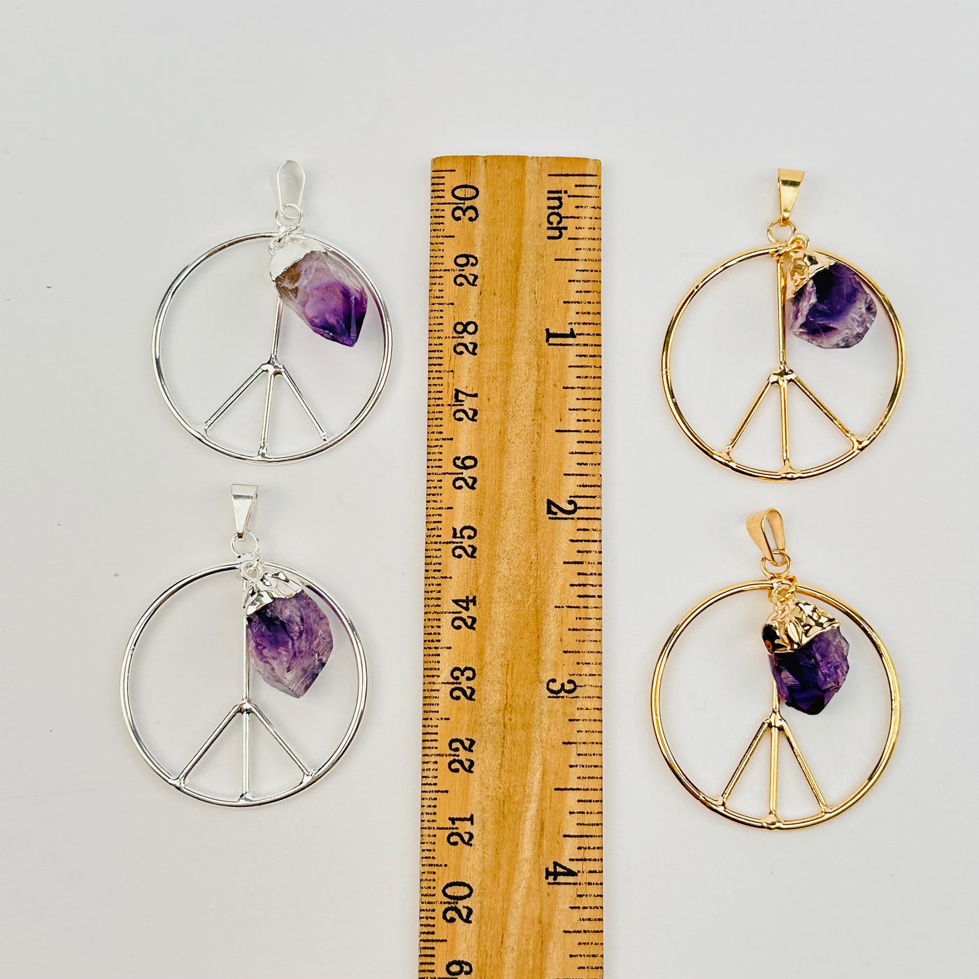 pendants next to a ruler for size references 