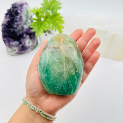 fluorite crystal cut base displayed in hand for size reference