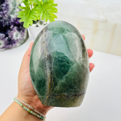 fluorite crystal cut base displayed in hand for size reference