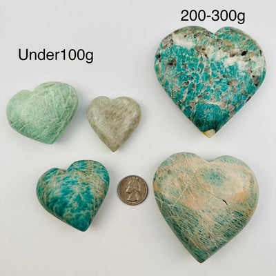 Amazonite Polished Heart - By Weight next to a quarter for size reference 