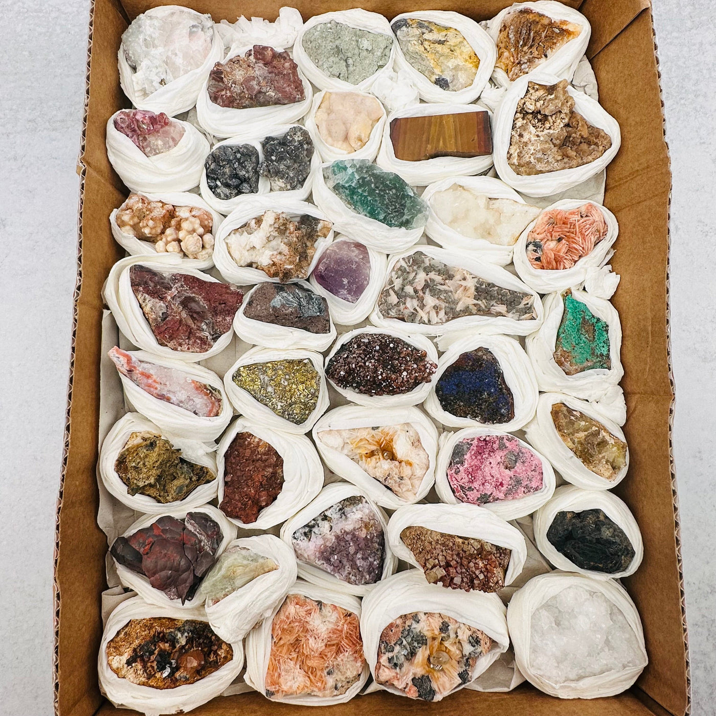 Assorted minerals in a brown box.
