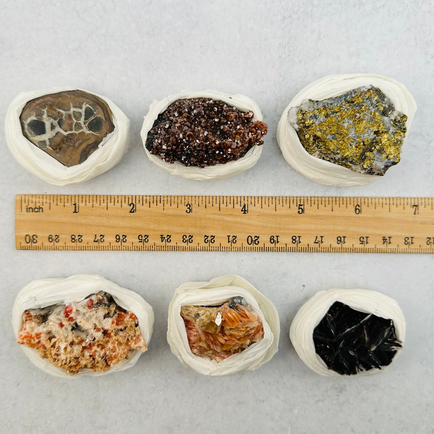 Assorted minerals next to a ruler showing they are about 1.75 inches wide.