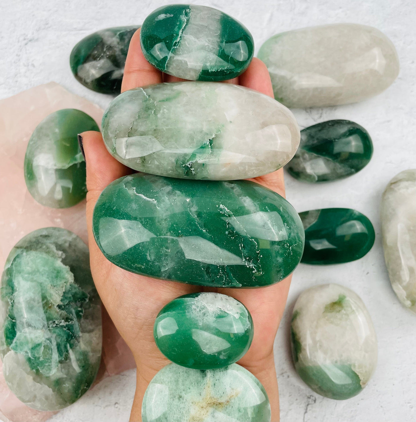 Green and White Palm Stones in hand for size reference 