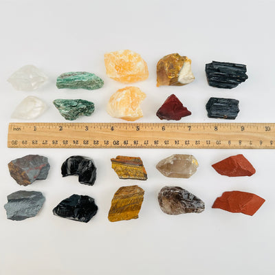 rough crystals next to a ruler for size reference 