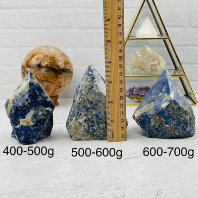 Sodalite Semi-Polished Point High End - By Weight. displayed next to a ruler for size reference