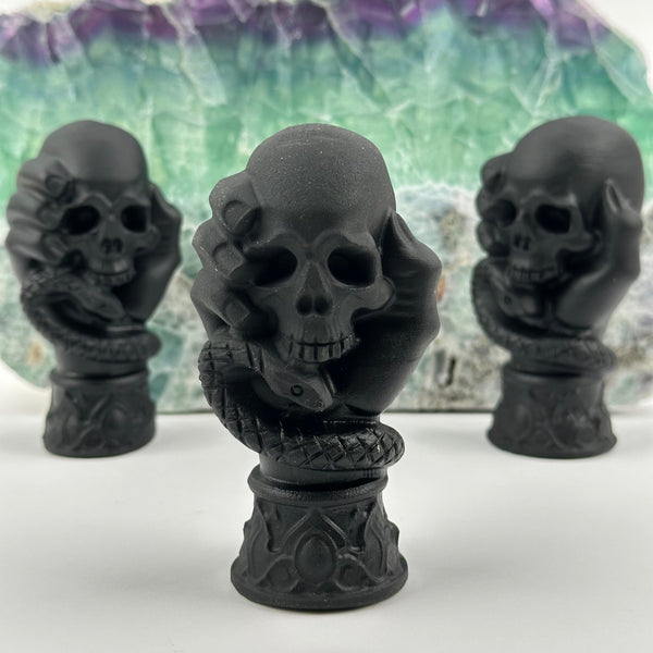 multiple Black Obsidian Crystal Skull on Hand displayed as home decor