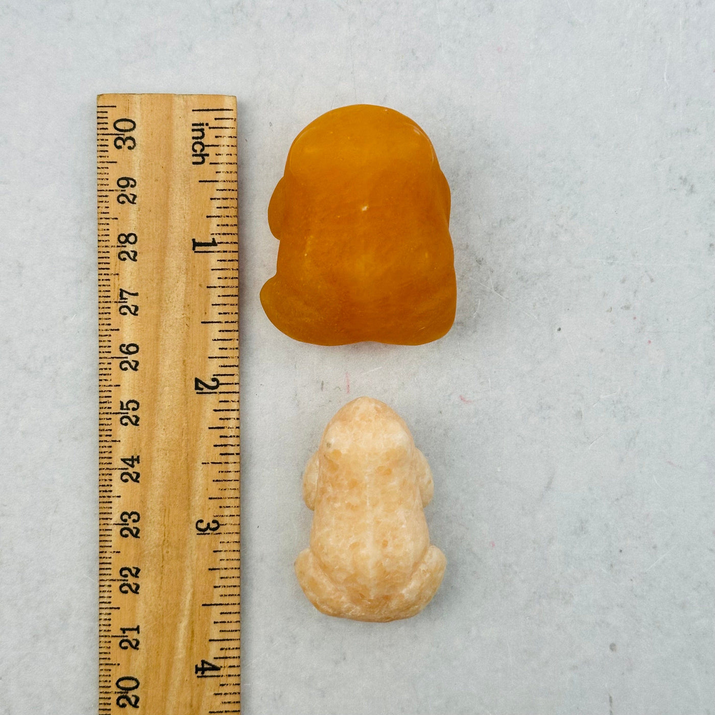 gemstone frog next to a ruler for size reference 