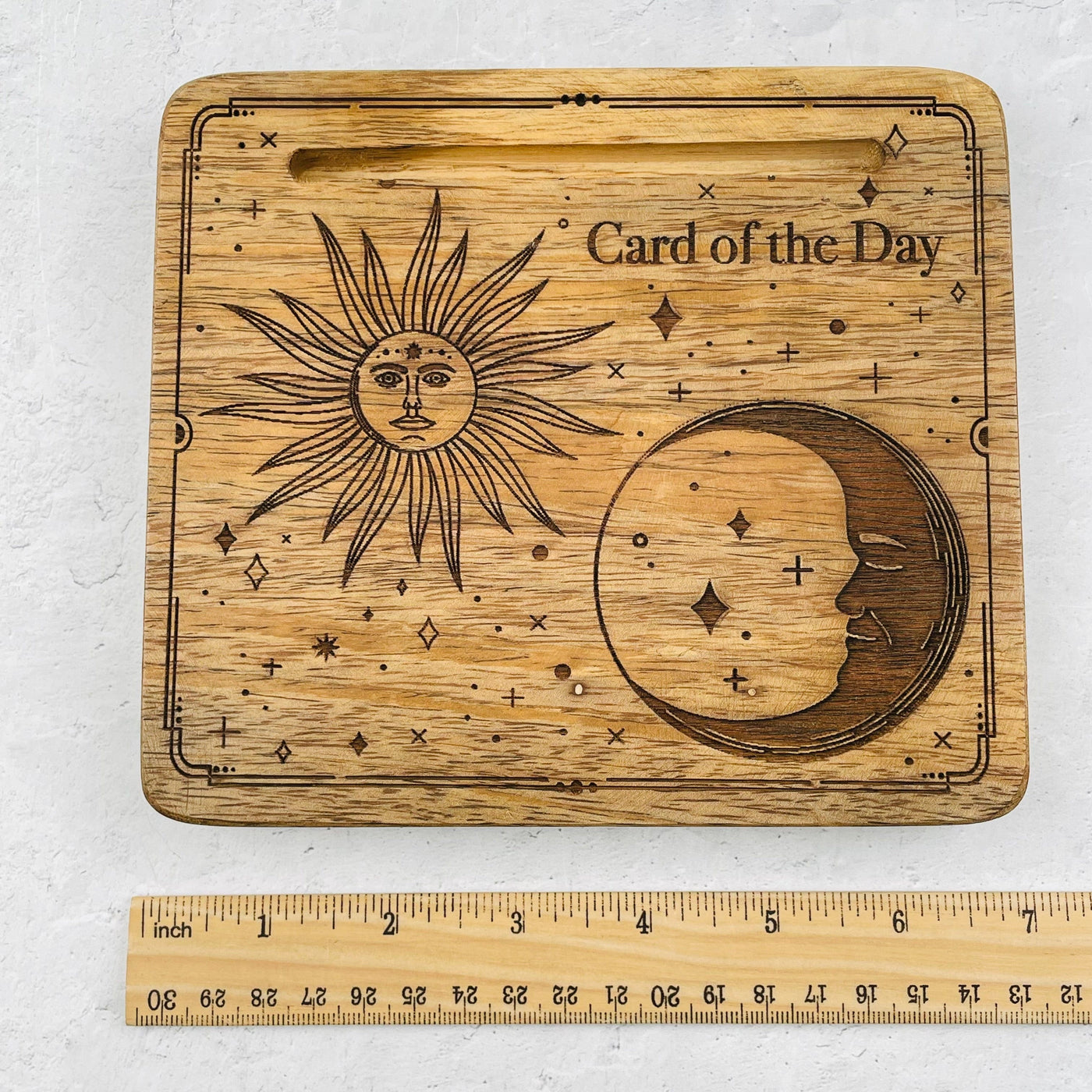 wood card holder next to a ruler for size reference 