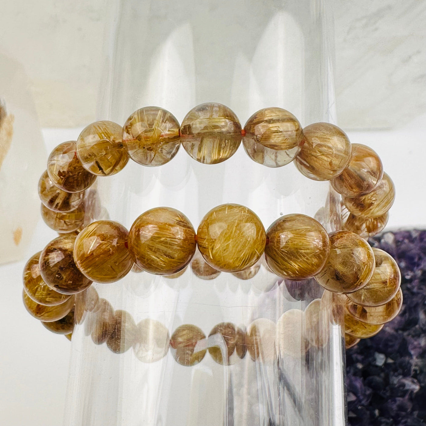 Gold Rutilated Round Bead Bracelets displayed next to each other to show the differences in the color shades 