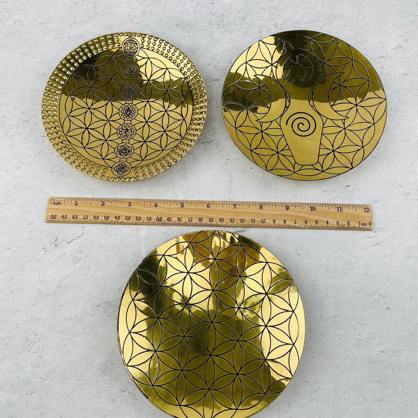 brass trays next to a ruler for size reference 