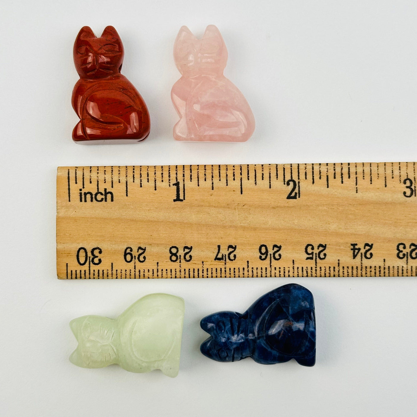 cat beads next to a ruler for size reference 