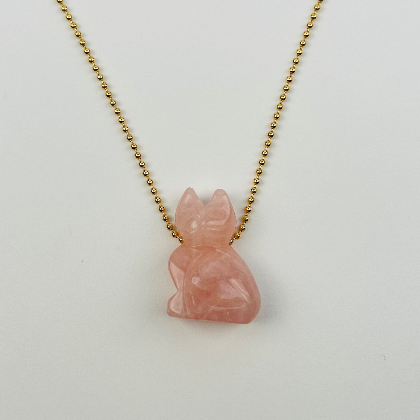 rose quartz cat bead displayed on necklace to show how it hangs 