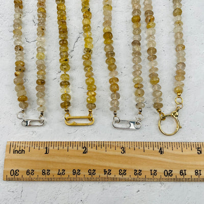 clasps next to a ruler for size reference 