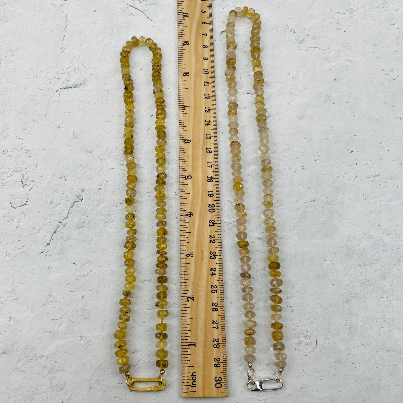 necklaces next to a ruler for size reference 