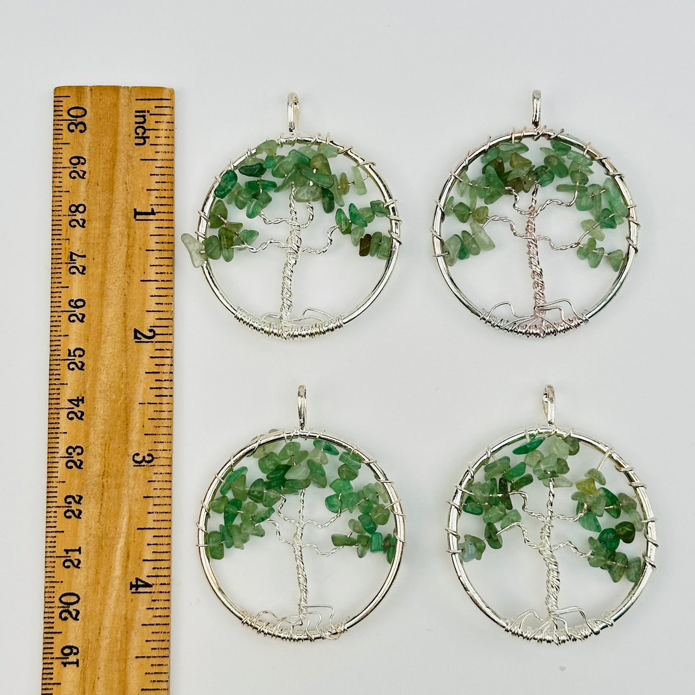 pendants next to a ruler for size reference 