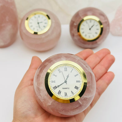 rose quartz crystal clock on hand for size reference 