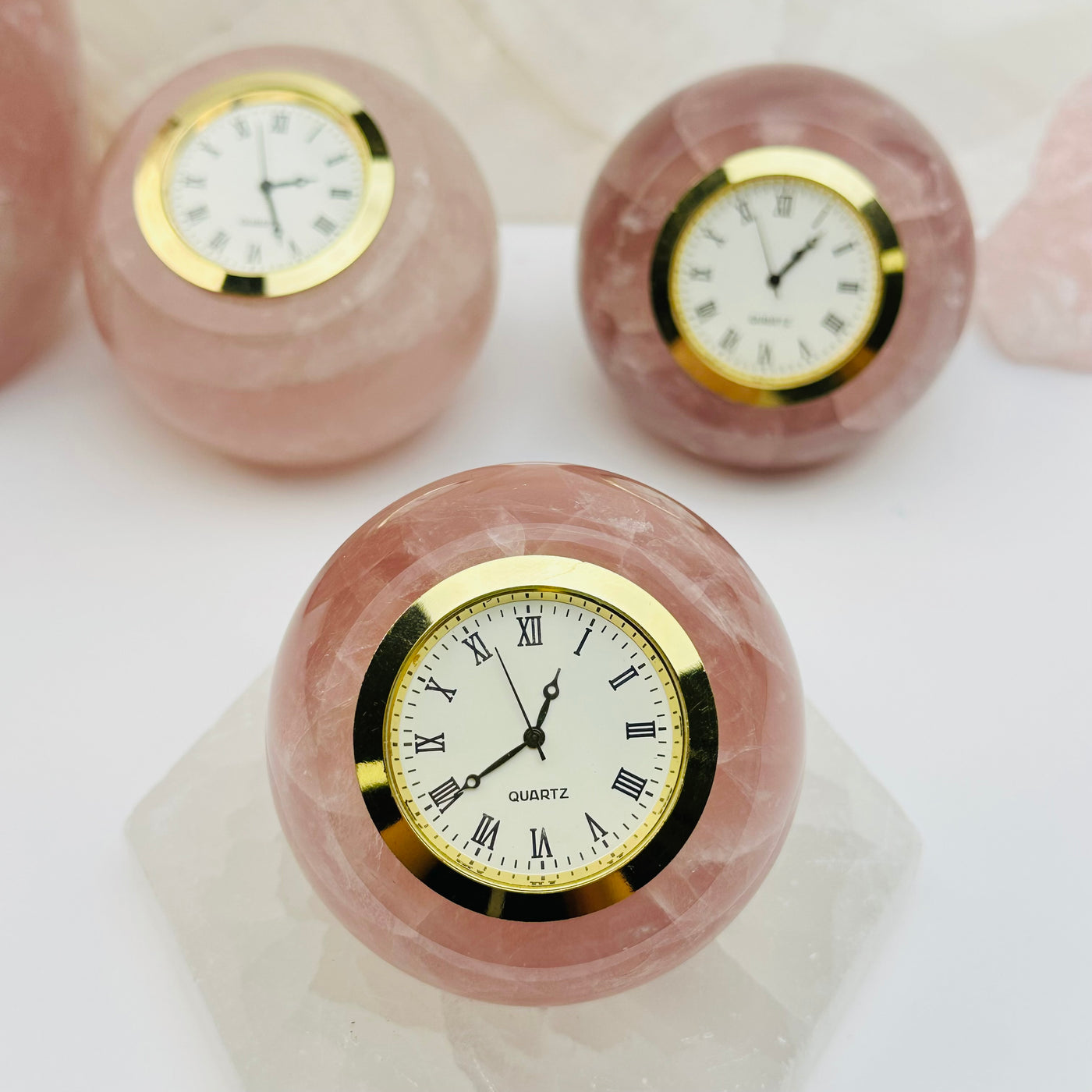 multiple rose quartz clocks displayed to show the differences in the color shades 