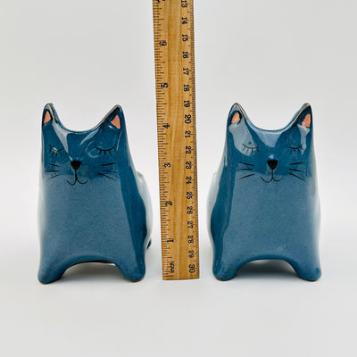 ceramic cat displayed next to a ruler for size reference 