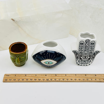 ceramic holders next to a ruler for size reference 