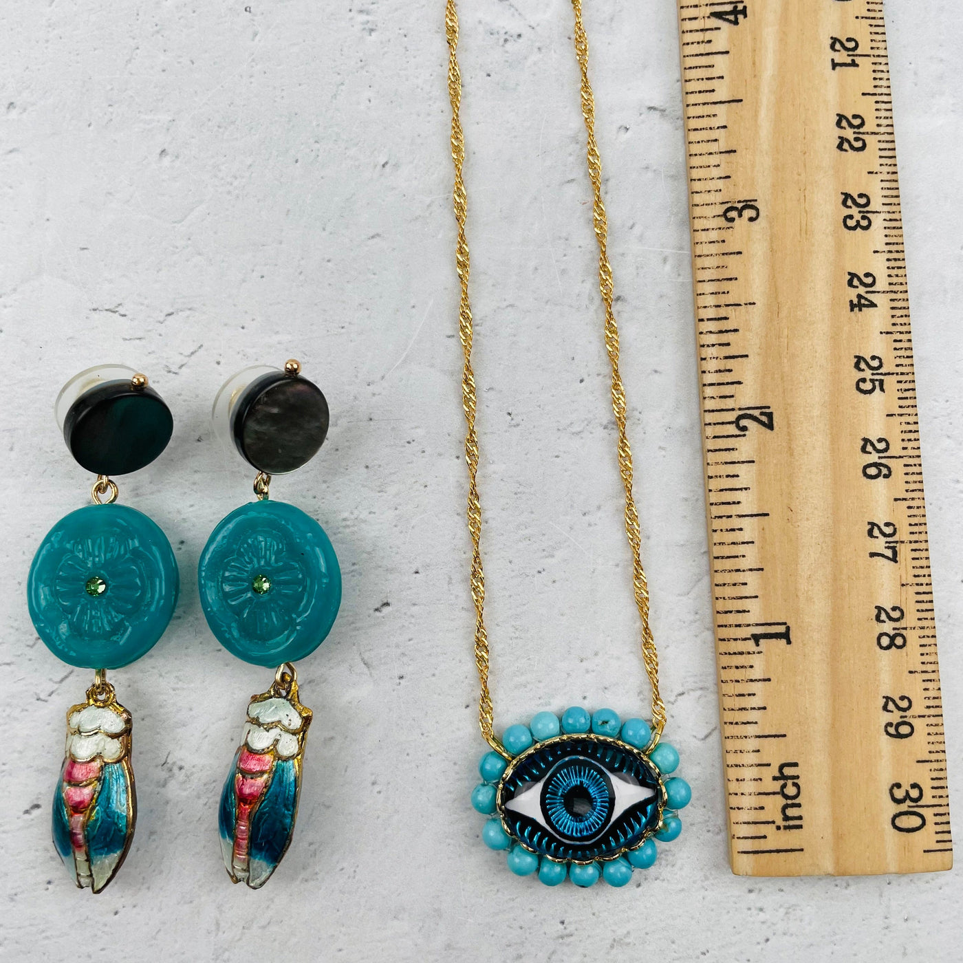earrings and pendant next to a ruler for size reference 