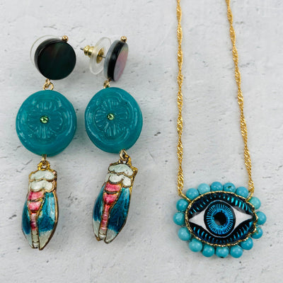 close up of the earrings and the evil eye pendant 