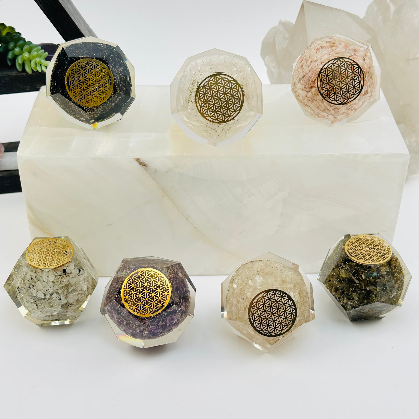 multiple Crystal Orgone Dodecahedron with Flower of Life displayed to show the differences in the crystal types 
