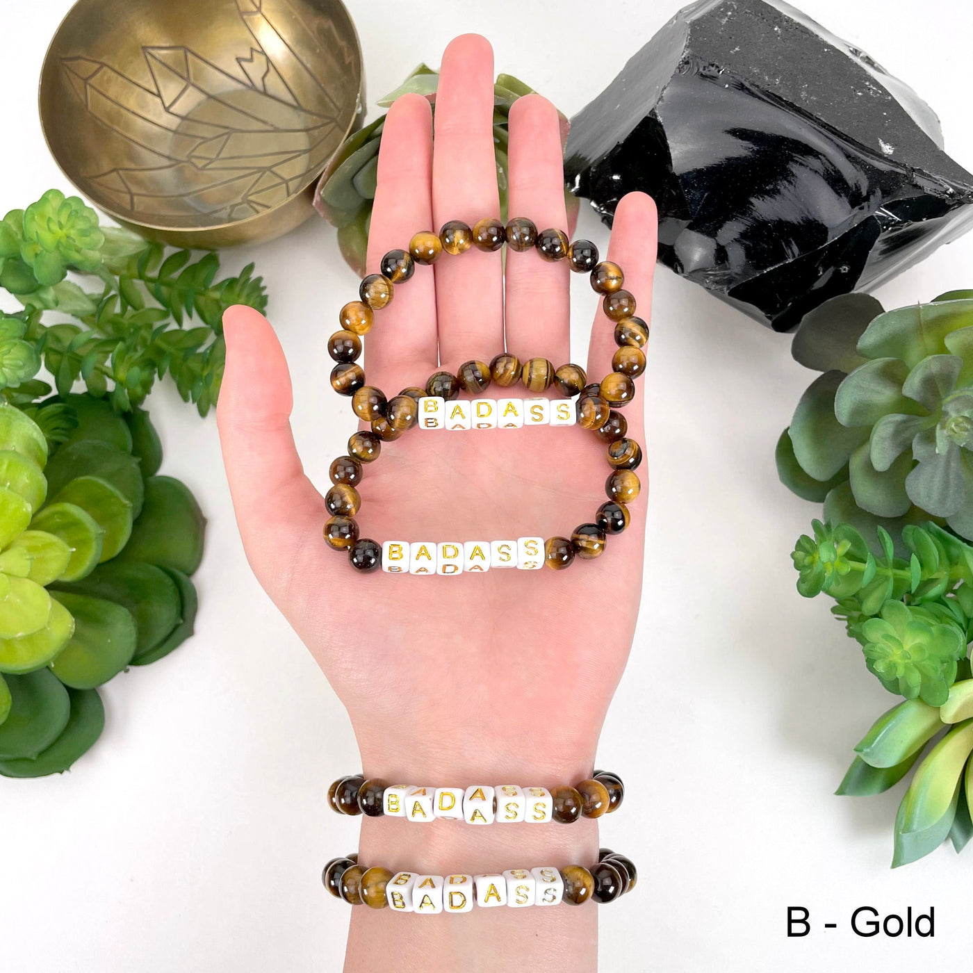 tigers eye beads with gold "BADASS" letter bead option in hand and on wrist for color reference