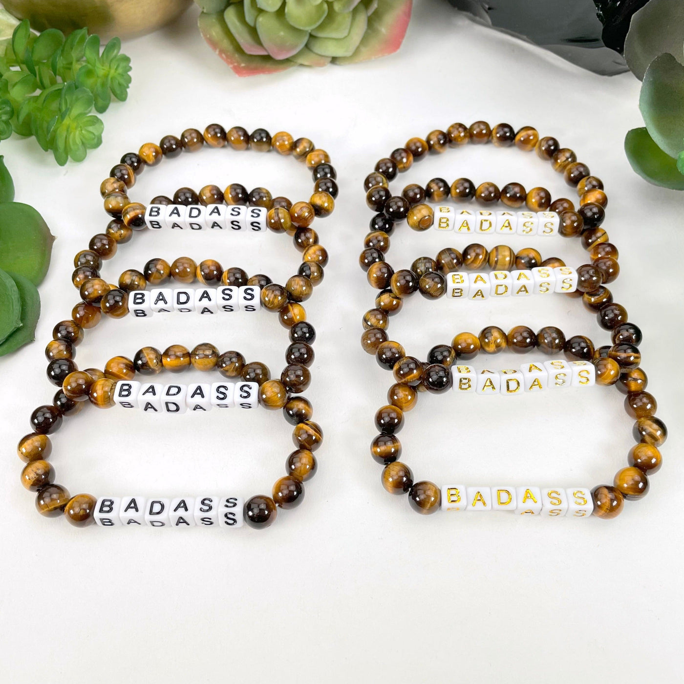 Tigers eye and black "BADASS" letter beads on left display and gold "BADASS" letter beads on right display