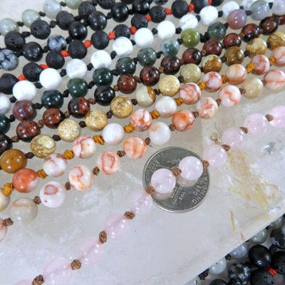Knotted Crystal Gemstone Necklaces lined up next to a quarter for size reference in assorted stones