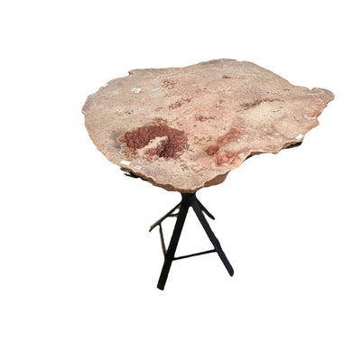 table is made out of a pink amethyst slab that has been cut and polished on one side 