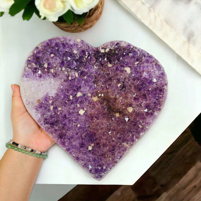 Large Amethyst Cluster Heart next to hand for size reference 