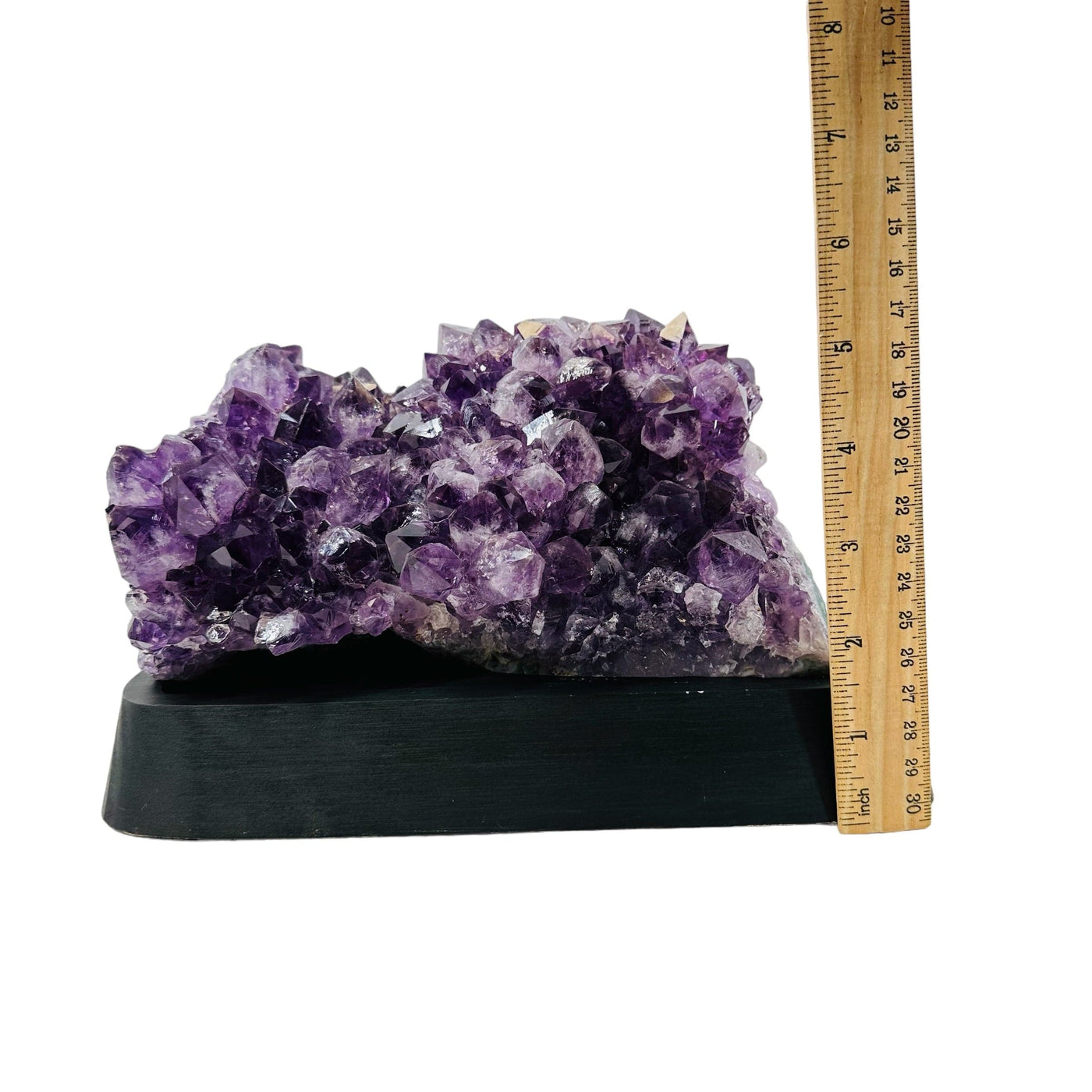 amethyst cluster next to a ruler for size reference 