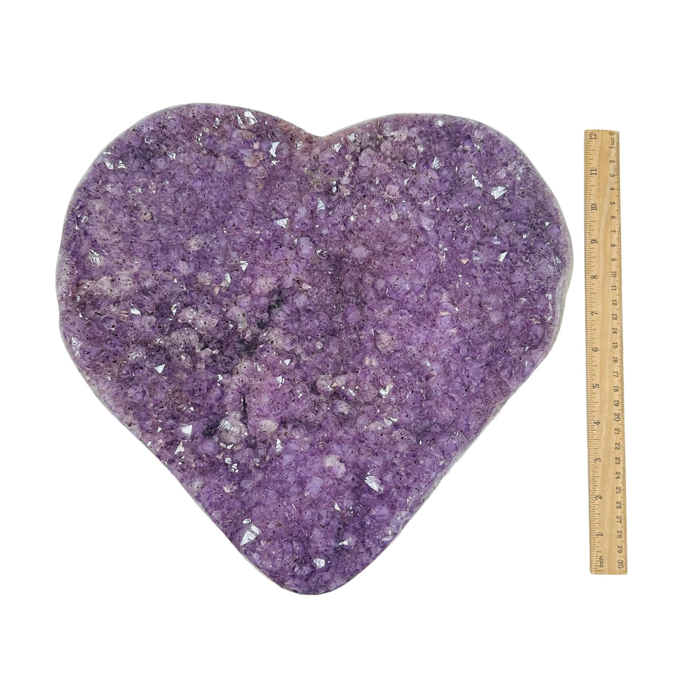 large amethyst heart next to a ruler for size reference 