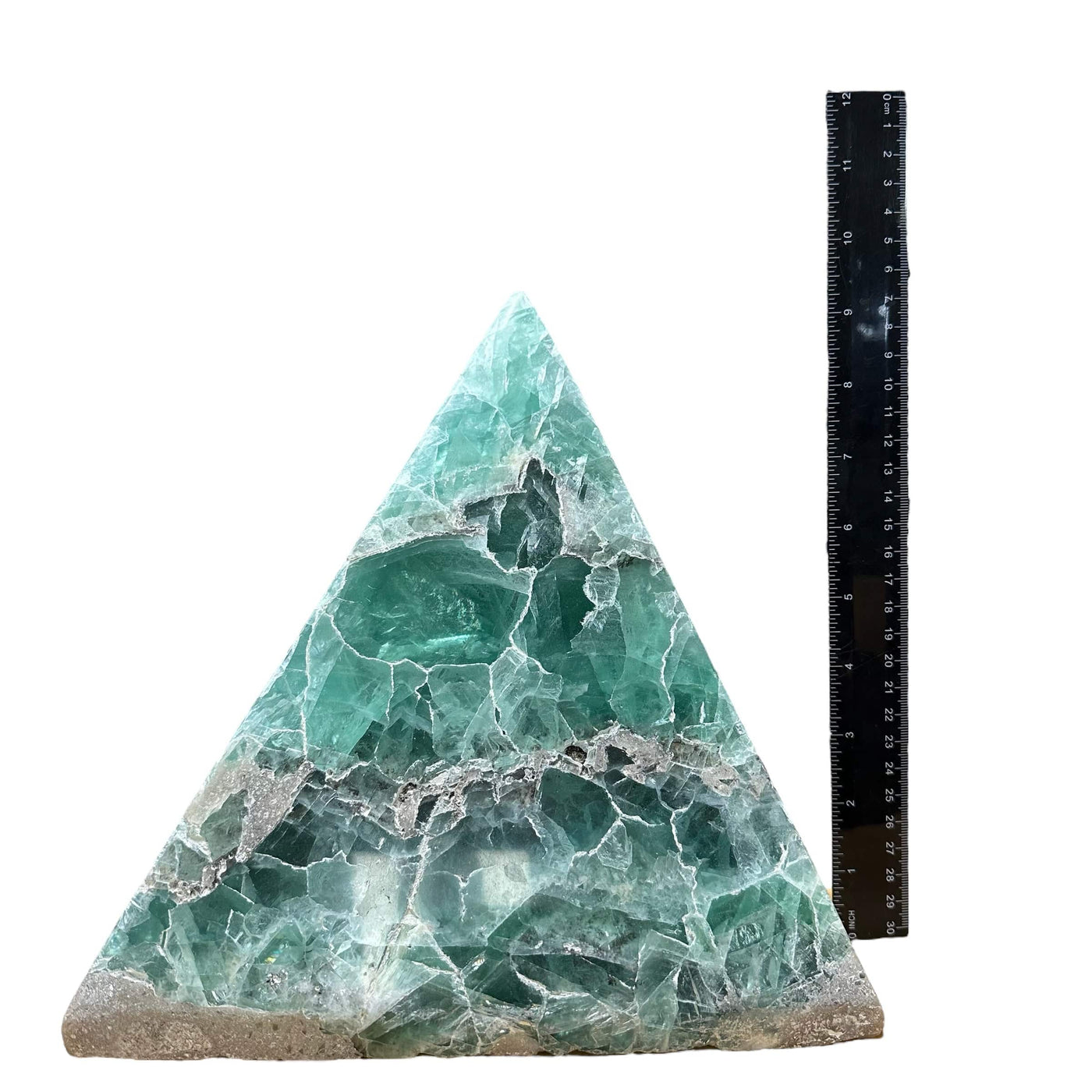 Large green fluorite pyramid on a white background with a ruler next to it showing it is about 11 inches tall.