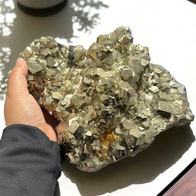 Large Pyrite cluster with Hexagon formations in hand for size reference 