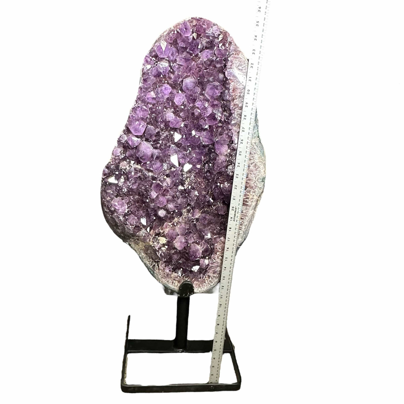 amethyst on stand next to a ruler for size reference 