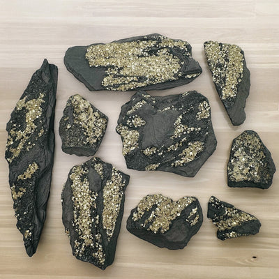 multiple Pyrite on Basalt Matrix crystals displayed to show the differences in the sizes and color shades 