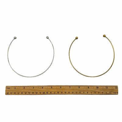 brass choker style necklaces displayed next to a ruler for size reference 
