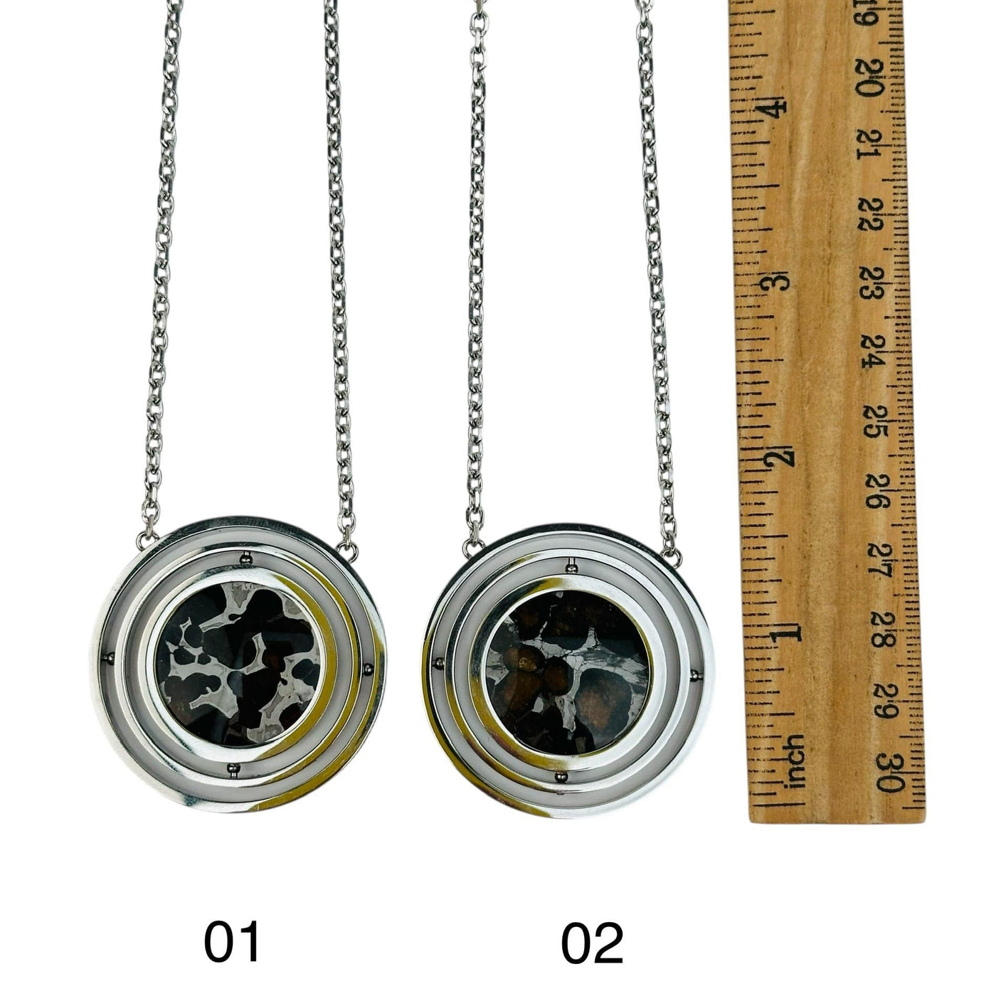 pendants next to a ruler for size reference 