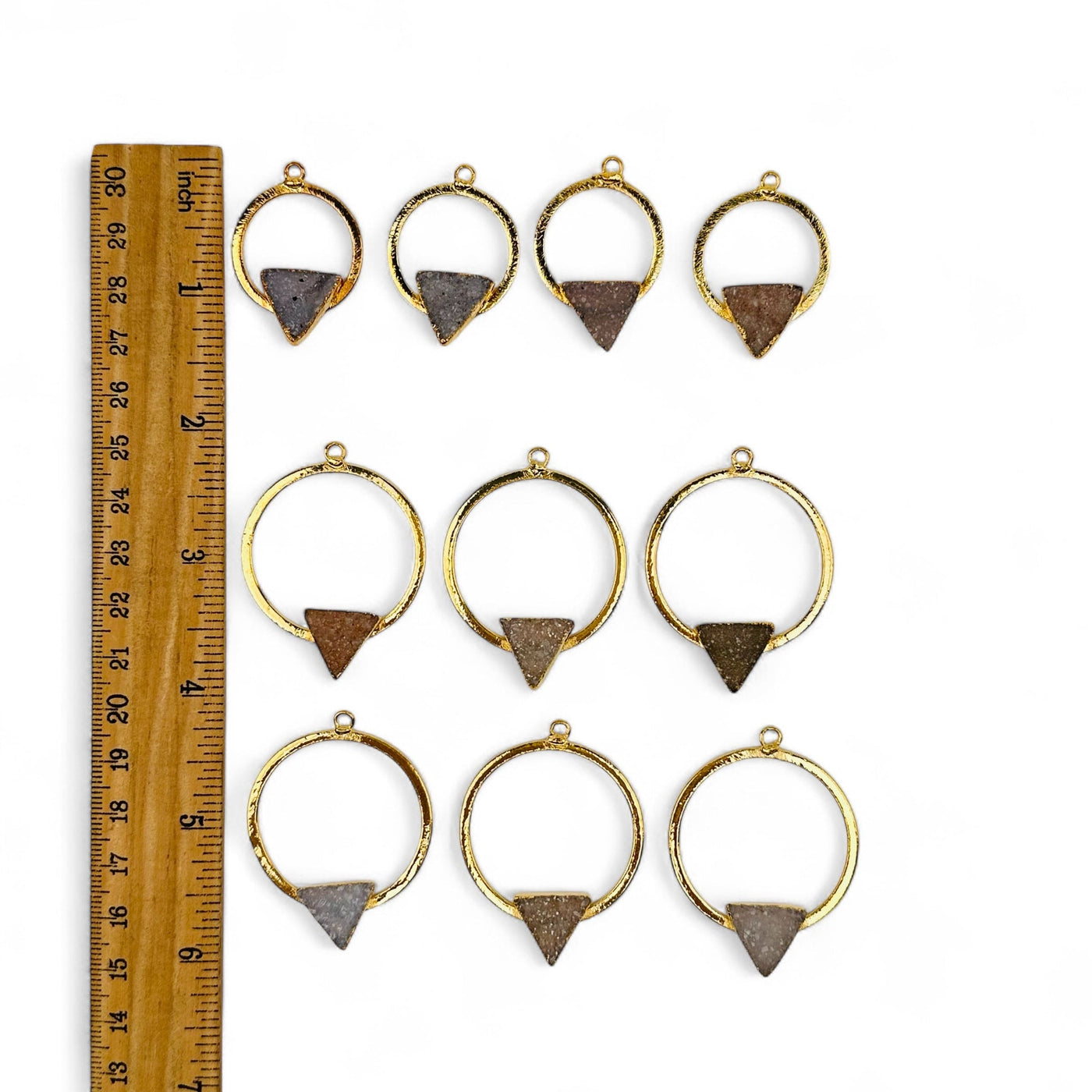 pendants next to a ruler for size reference 