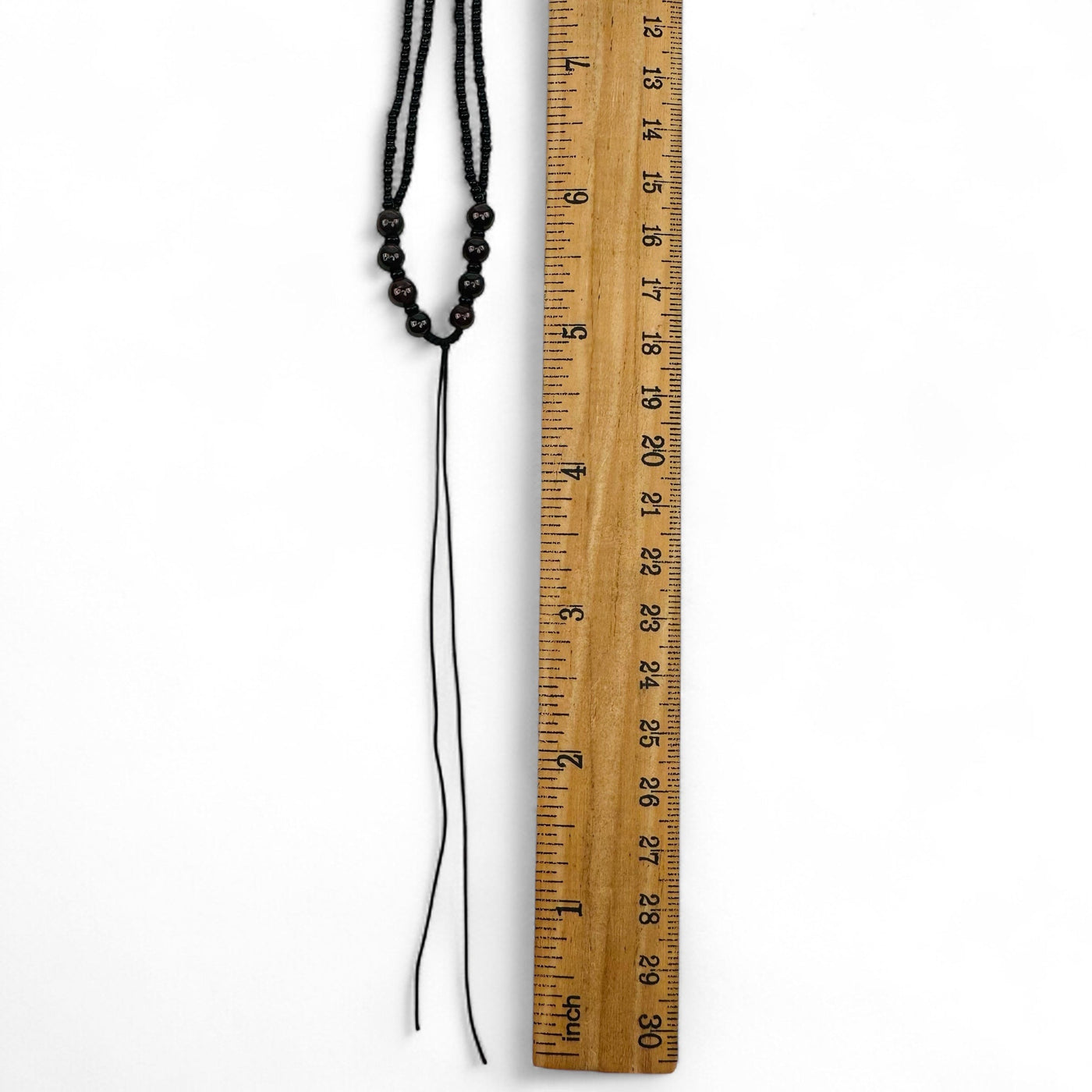 necklace next to a ruler for size reference 