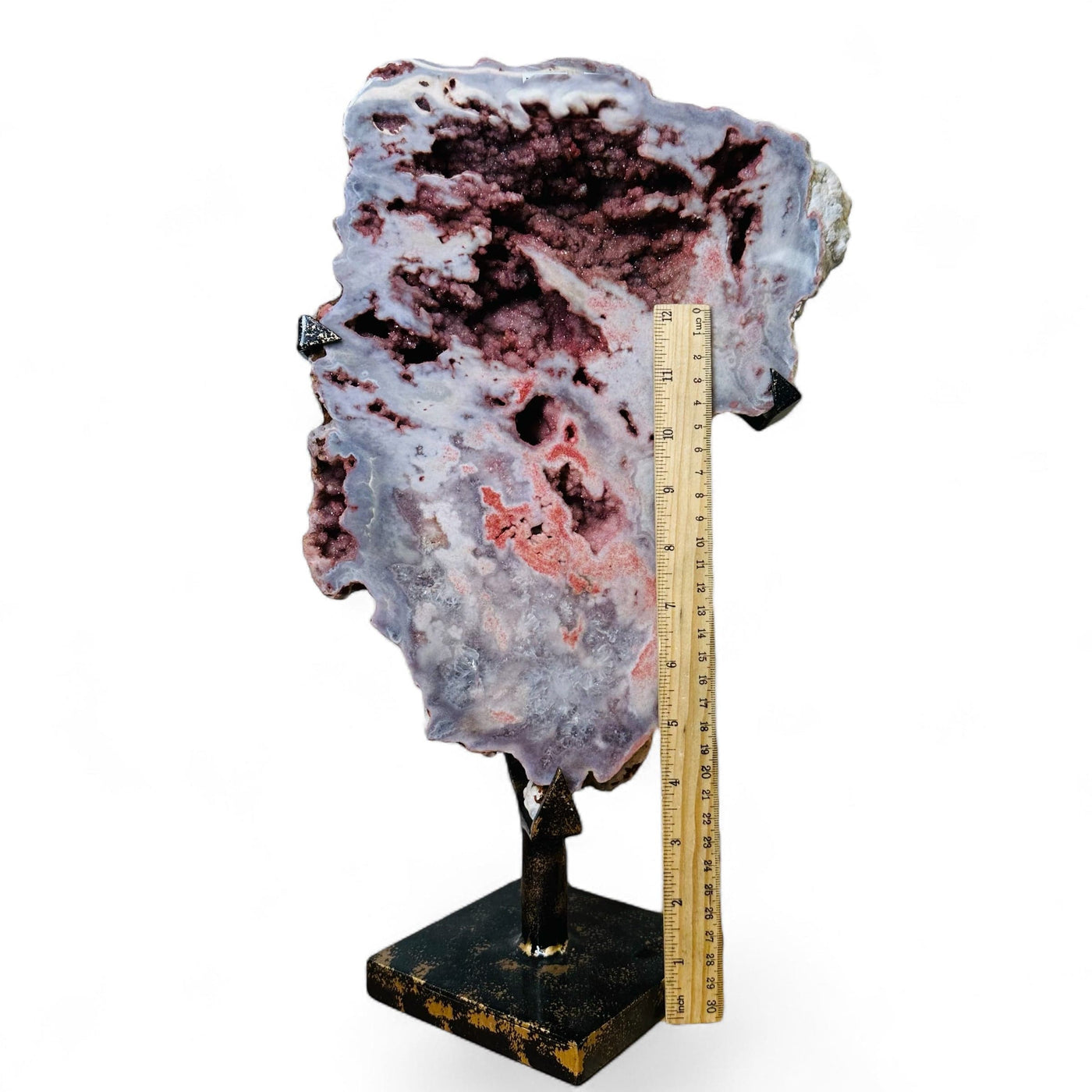 pink amethyst on metal stand next to ruler for size reference  