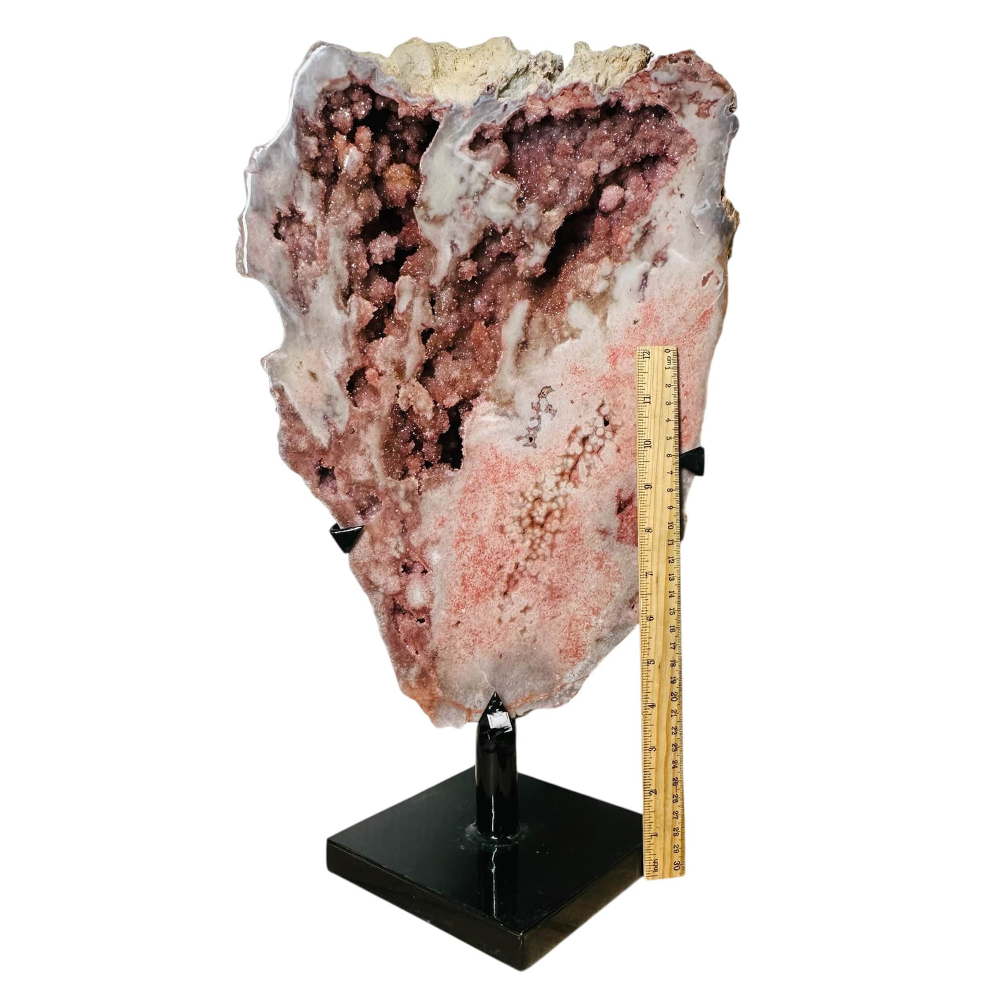 pink amethyst crystal next to a ruler for size reference 