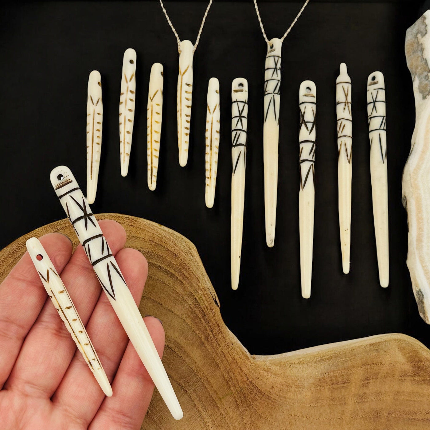 bone spike bead pendant in hand for size reference 
