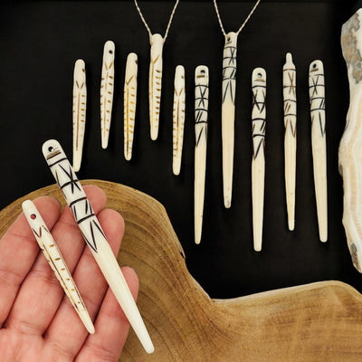 bone spike bead pendant in hand for size reference 