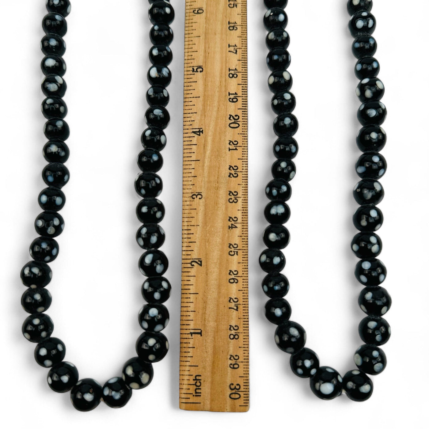 close up of the beads displayed next to a ruler for size reference 