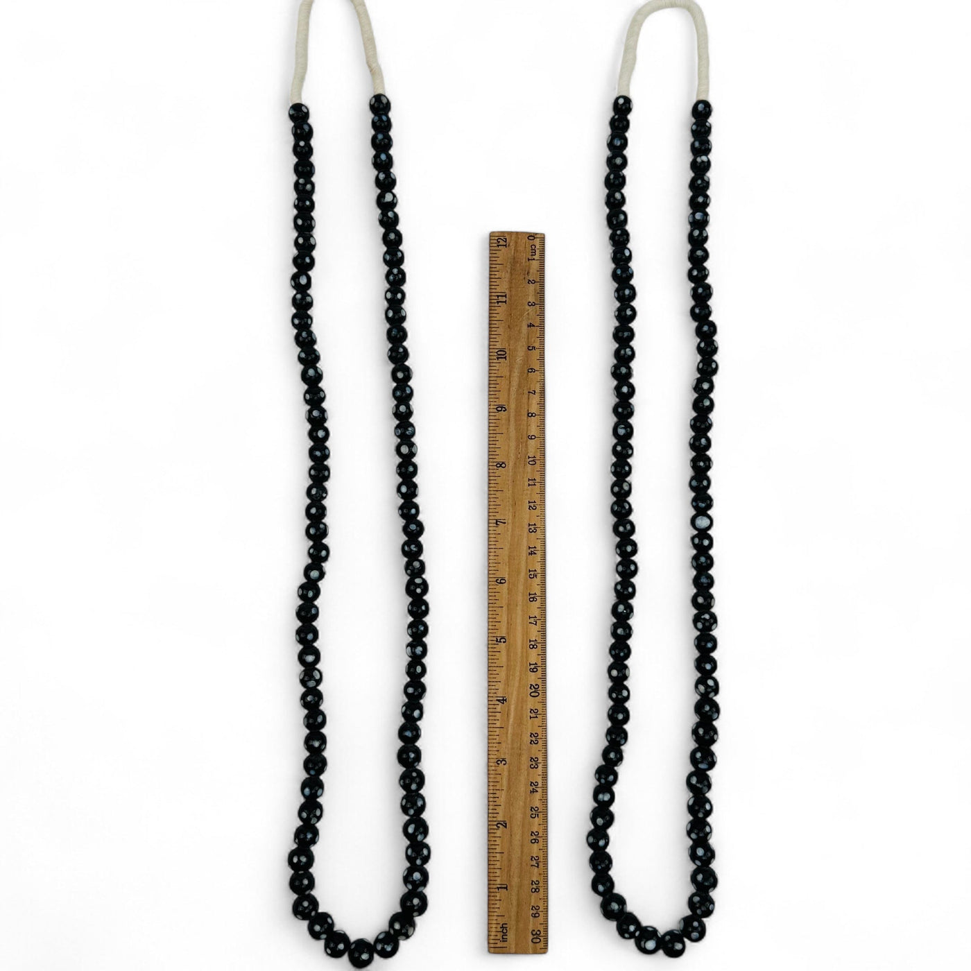 necklaces displayed next to a ruler for size reference 