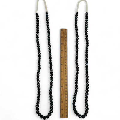 necklaces displayed next to a ruler for size reference 
